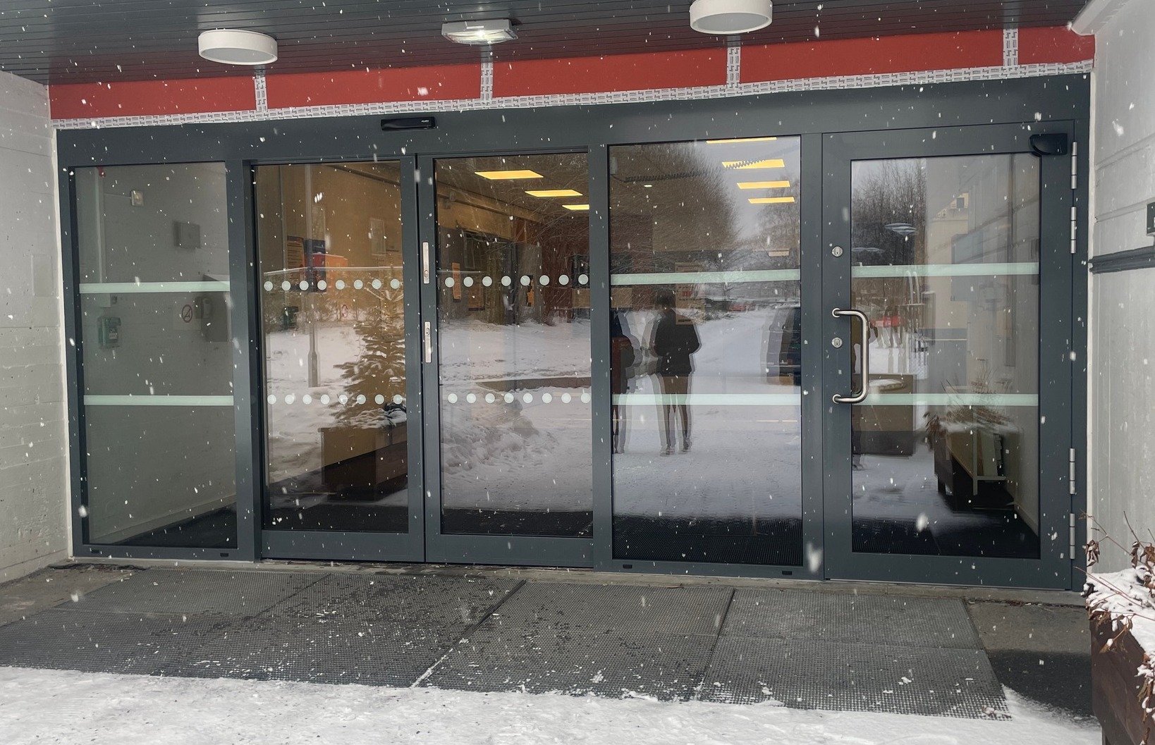 Her har vi skiftet ut et gammelt inngangsparti som bestod av 3stk slagdører. Inngangspartiet ble omgjort med et skyvedørsfelt i Schüco aluminium pluss en slagdør som personalinngang på høyre side. Vi monterte her Gilgen skyvedørsautomatikk og Dormakaba slagdørsautomatikk med BEA sine 3D Flatscan sikkerhetssensorer.